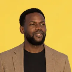 Kiye Mateus, web strategist in Geneva, in a beige jacket against a yellow background